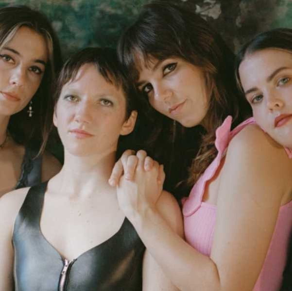Photo of four female musicians looking into the camera