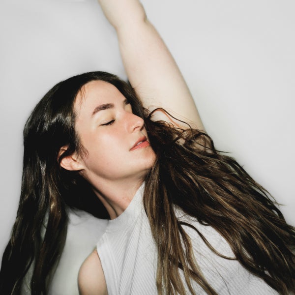 Photo of singer-songwriter Mia Wray eyes closed and leaning to one side